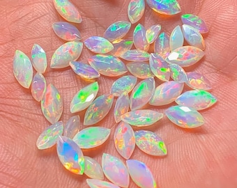 May include: A collection of iridescent white opal marquise gemstones. The opals are faceted and have a pearlescent sheen.