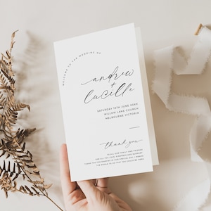 Puede incluir: Una tarjeta de invitación de boda blanca con texto negro. El texto dice "Bienvenido a la boda de Andrew + Lucille" e incluye la fecha, la ubicación y las palabras "Gracias" con un mensaje de agradecimiento a la familia y los amigos.