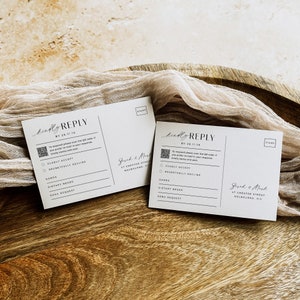 May include: Two white RSVP cards with a black and white QR code, the text "kindly reply" and the text "By 28.11.19". The cards have a section for guests to indicate whether they will be attending the event, and a section for guests to provide their names, dietary needs, and song requests.