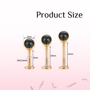 May include: Three gold-coloured lip piercing studs with dark green gemstone tops. The studs are 3mm in diameter, with lengths of 8mm, 10mm, and 12mm. The text "Product Size" is at the top of the image.