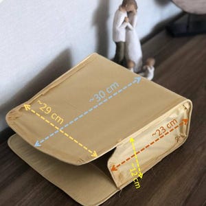 Könnte beinhalten: Eine beige Stoffaufbewahrungsbox mit in Zentimetern markierten Maßen. Die Box ist etwa 30 cm lang, 29 cm breit und 23 cm tief.