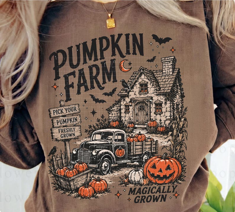 Peut inclure: Un sweat-shirt marron avec une impression graphique portant le texte PUMPKIN FARM et MAGICALLY GROWN. Le motif comprend une maison, un camion, des citrouilles, des chauves-souris et un panneau indiquant PICK YOUR PUMPKIN, PUMPKIN, FRESHLY GROWN.