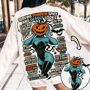 May include: White sweatshirt with a Halloween-themed graphic. The design features a woman with a pumpkin head, wearing a black corset and boots. Text includes "Serving Pumpkin Spice and Deadly Looks" and "I'm 99% That Witch."