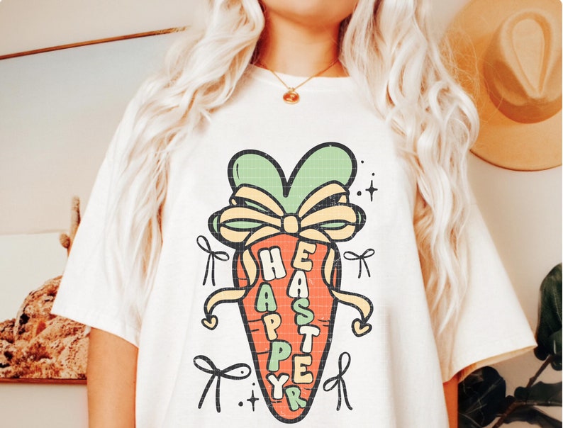 May include: A white t-shirt with a cartoon carrot design. The carrot is tied with a yellow ribbon and has the words "Happy Easter" written on it.