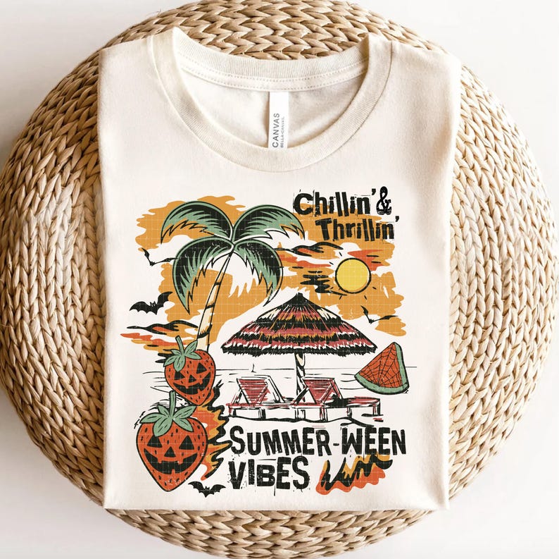 May include: Cream-colored t-shirt with a graphic design featuring a palm tree, beach umbrella, and the text "Chillin' & Thrillin', Summer-ween Vibes". The design includes bats, a sun, and jack-o'-lantern strawberries.