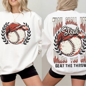 May include: White sweatshirt with a baseball graphic and the text "Thou Shall Not Steal Unless You Can Beat The Throw" printed on the back.