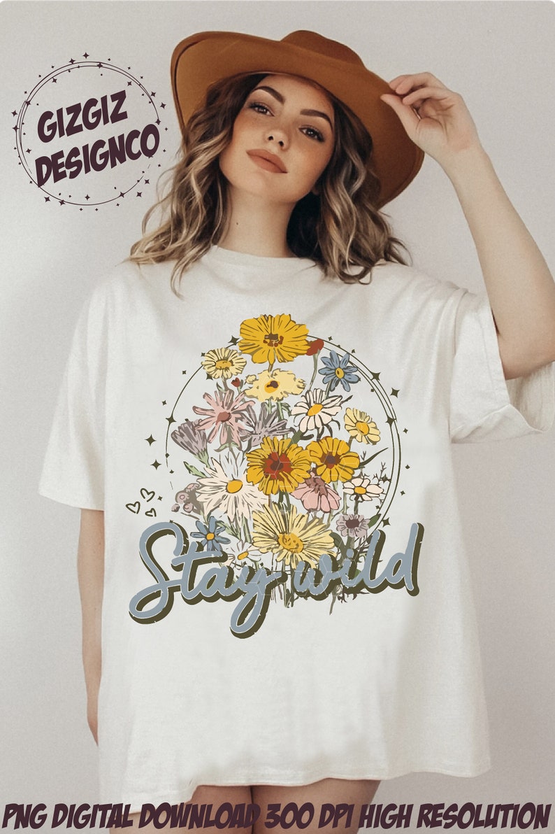 May include: White t-shirt with a floral design and the text "Stay Wild" in a green and blue font.
