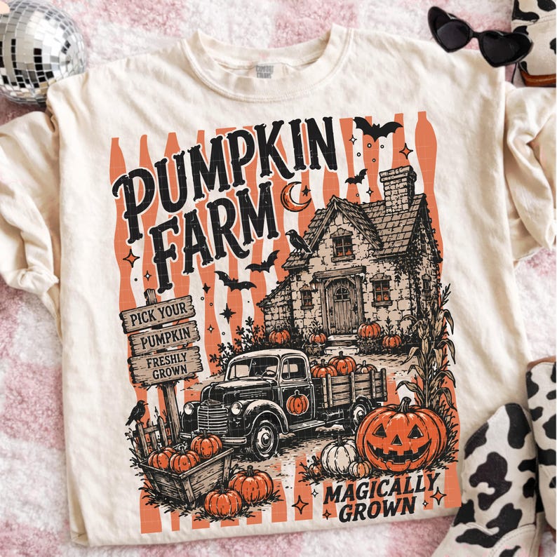 Peut inclure: Un t-shirt cr&egrave;me avec une impression graphique portant le texte PUMPKIN FARM et MAGICALLY GROWN. Le motif repr&eacute;sente une maison rustique, un vieux pick-up, un panneau en bois, des citrouilles, des chauves-souris et un croissant de lune.