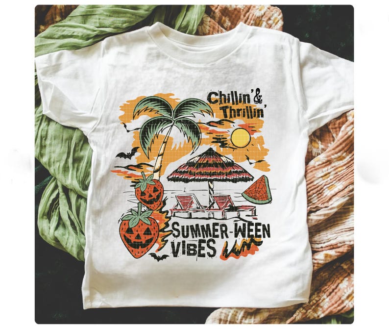 May include: White t-shirt with a colorful graphic featuring a beach scene with a palm tree, sun, and text that reads "Chillin' & Thrillin'" and "Summer-ween Vibes". The design includes jack-o'-lantern strawberries, a beach umbrella, and a slice of watermelon.