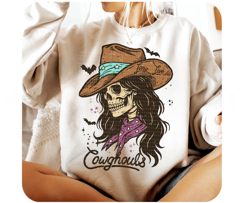 May include: Cream-colored sweatshirt featuring a graphic of a skull wearing a cowboy hat with the words "Long Live" and a purple bandana. The design includes bats and the word "Cowghouls".