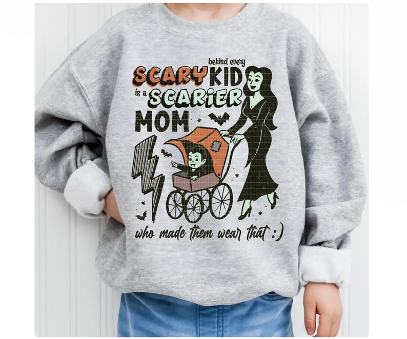 May include: A light gray sweatshirt with the text "behind every SCARY KID is a SCARIER MOM who made them wear that :)". The graphic includes a vampire in a stroller and a woman in a black dress.