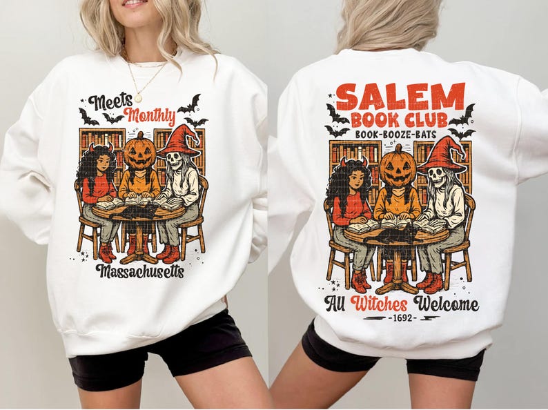 Może przedstawiać: Biała bluza z grafiką o tematyce Halloween. Prz&oacute;d przedstawia kresk&oacute;wkę trzech postaci wok&oacute;ł stołu z napisem "Meets Monthly Massachusetts". Tył m&oacute;wi "Salem Book Club" i "All Witches Welcome".