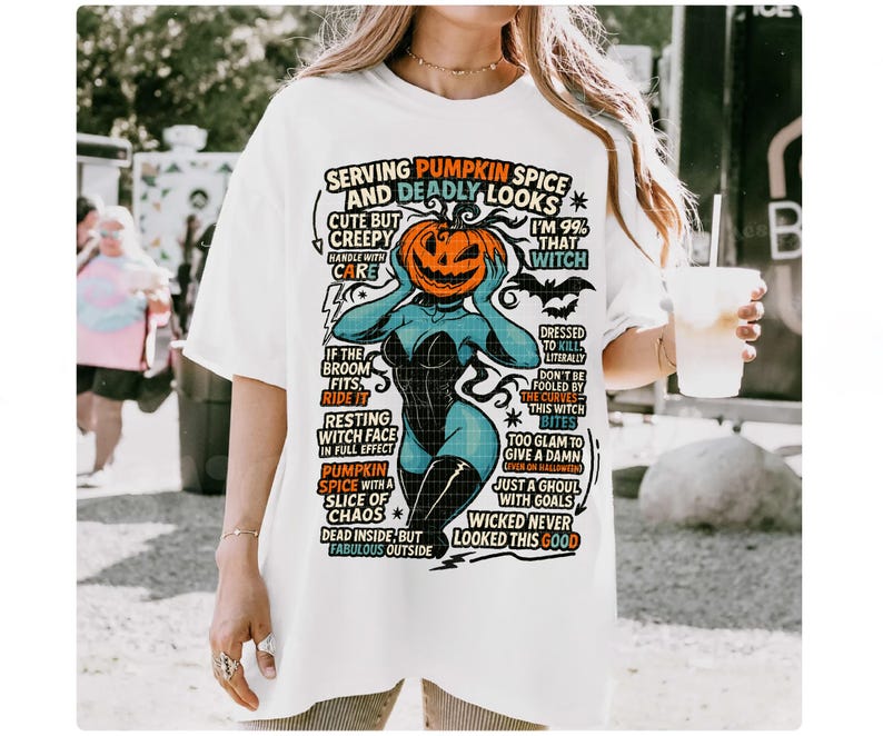 May include: White t-shirt with a Halloween-themed graphic. The design features a pumpkin-headed witch with text that reads "Serving Pumpkin Spice and Deadly Looks." The shirt has a relaxed fit and short sleeves.