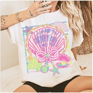 Puede incluir: Camiseta blanca con un estampado gráfico de una concha rosa con perlas, una estrella de mar y el texto "Summer vibes Summer vibes Summer vibes Summer vibes".