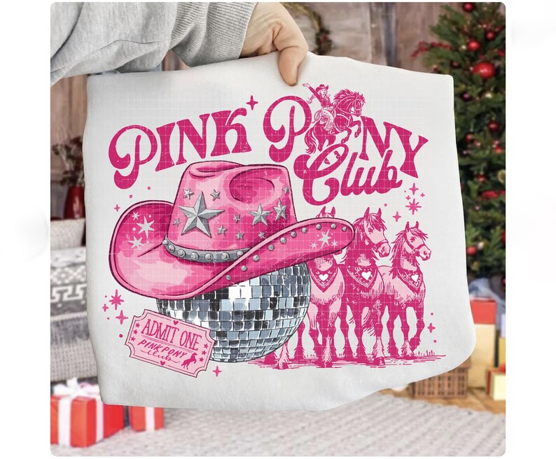 May include: White pillow with a pink graphic design featuring a cowboy hat, disco ball, and horses. The text "PINK PONY CLUB" is displayed above the hat. An "ADMIT ONE" ticket is also visible.