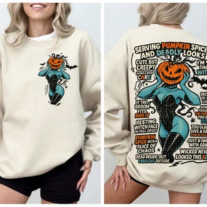 May include: Beige sweatshirt with a Halloween-themed graphic. The front features a teal figure with a pumpkin head and bats. The back has the text "Serving Pumpkin Spice and Deadly Looks" with a similar graphic and additional text.