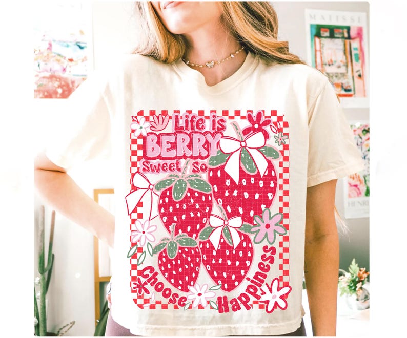 May include: A white t-shirt with a graphic of strawberries and the text "Life is Berry Sweet So Choose Happiness".