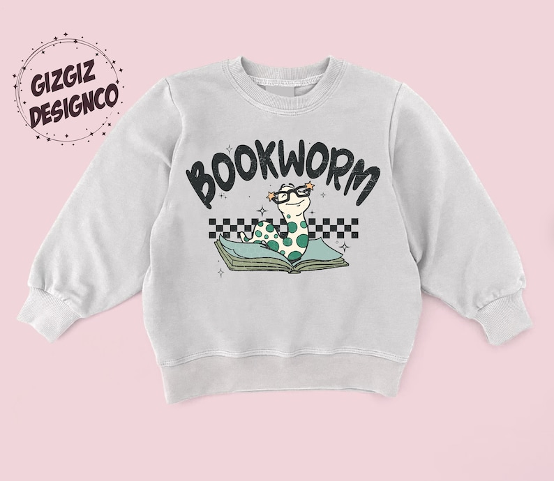 Pu&ograve; includere: Una felpa grigia chiaro con una grafica di un verme che indossa gli occhiali e legge un libro. Il testo "BOOKWORM" &egrave; sopra il verme.