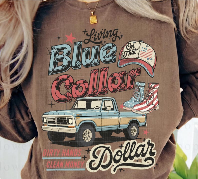 May include: Brown t-shirt with a graphic design featuring a blue and yellow pickup truck, a baseball cap, and boots. The text reads "Living Blue Collar Dollar" with additional text "Dirty Hands Clean Money."