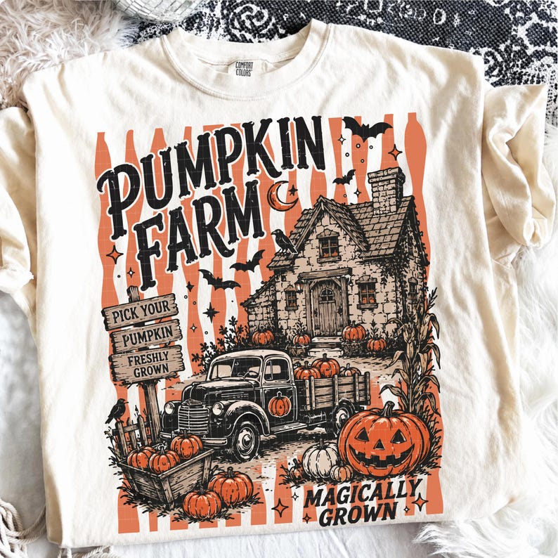 Peut inclure: Un t-shirt cr&egrave;me avec une impression graphique portant le texte PUMPKIN FARM et MAGICALLY GROWN. Le motif comprend un camion vintage, une maison, des citrouilles, des chauves-souris, un corbeau et un panneau en bois PICK YOUR PUMPKIN FRESHLY GROWN.