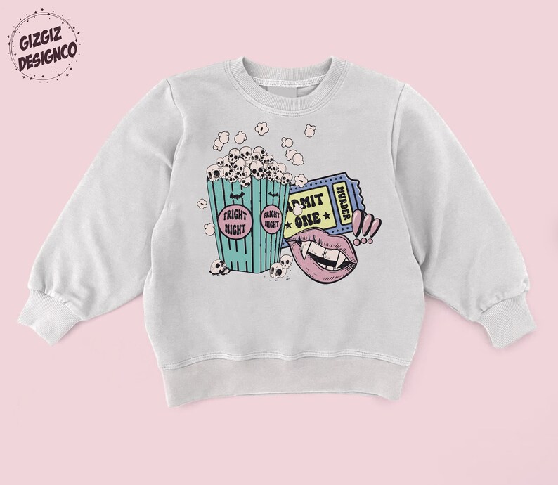 May include: A light gray sweatshirt with a graphic print of a bucket of popcorn with skulls, a ticket that says "Admit One" and "Murder", and a vampire mouth with fangs.