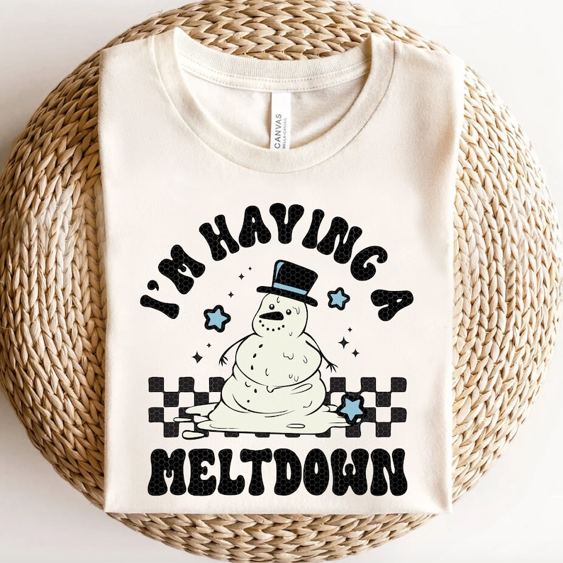 Pu&ograve; includere: Una maglietta bianca con una grafica nera di un pupazzo di neve che si scioglie con il testo "I'm having a meltdown".