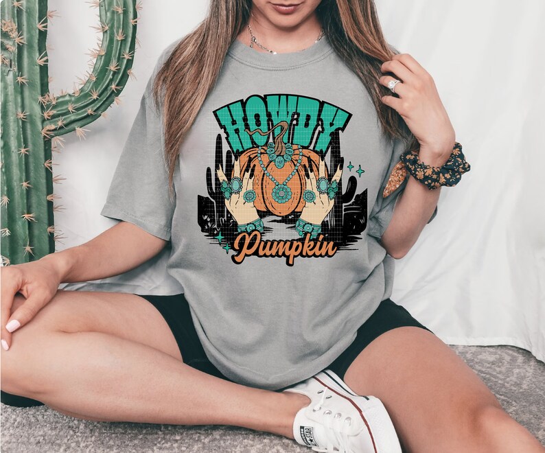 May include: A gray t-shirt with a graphic of a pumpkin with jewels and the text "Howdy Pumpkin".