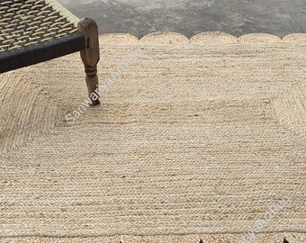 Könnte beinhalten: Ein Naturfaser-Teppich mit einem gewellten Rand. Der Teppich ist aus Jute und hat eine hellbraune Farbe. Der Teppich ist rechteckig und hat eine gewebte Textur.