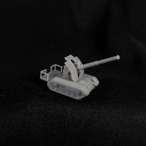 Puede incluir: Un modelo de plástico gris de un cañón antiaéreo autopropulsado. El cañón está montado en un chasis de orugas y tiene un cañón largo.