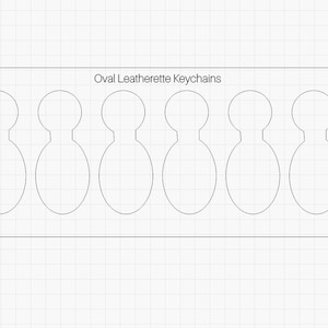 May include: A white rectangular sheet with the text "Oval Leatherette Keychains" printed at the top. The sheet has six oval cutouts for making keychains.