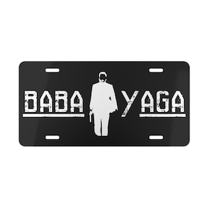 May include: Black and white license plate with the text "BABA YAGA" and a silhouette of a person in a suit.