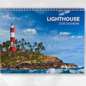 May include: A spiral-bound 2026 calendar featuring a red and white striped lighthouse on a rocky island with palm trees. The background shows a blue sky with white clouds and ocean waves.