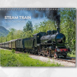 以下が含まれることがあります： ヴィンテージ蒸気機関車をフィーチャーした2026年カレンダー。画像には、緑の木々に囲まれた風景の中を線路を走る、黒い蒸気機関車と長い客車列車の姿が写っています。カレンダーのタイトルは白い文字で「STEAM TRAIN 2026 CALENDAR」と書かれています。