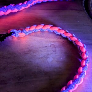 Puede incluir: Un cord&oacute;n trenzado con un esquema de color rosa y morado. El cord&oacute;n est&aacute; hecho de un material suave y flexible y tiene un dise&ntilde;o tejido.
