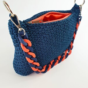 Bolso azul vaquero mediano, tipo baguette o bolso de hombro, tejido a crochet, hecho a mano, con asa acrílica azul y naranja, forro interior de tela satén naranja y cierre de cremallera.