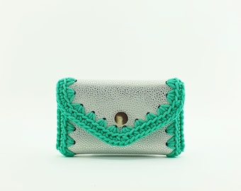 Handmade white leather purse with turquoise cord crocheted edge.