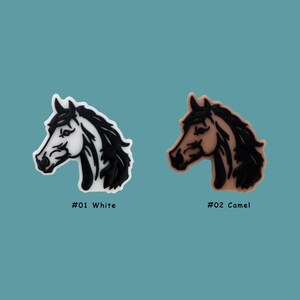 May include: Two horse head charms, one white and one camel colored, with black outlines. The charms are labeled #01 White and #02 Camel.