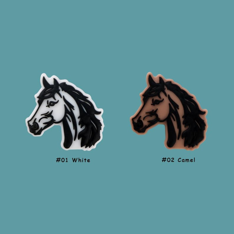 May include: Two horse head charms, one white and one camel colored, with black outlines. The charms are labeled #01 White and #02 Camel.