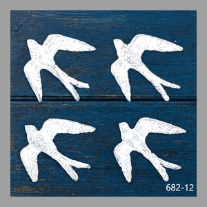 May include: Four white swallow-shaped wall decorations are arranged on a dark blue, textured wooden surface. The birds have outstretched wings and detailed tail feathers. The number "682-12" is printed in the bottom right corner.