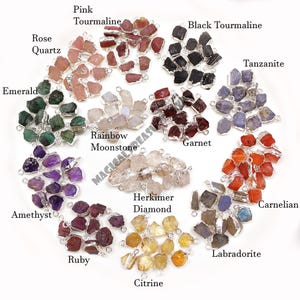 May include: A collection of raw gemstone pendants with silver-toned metal loops, labelled as Pink Tourmaline, Black Tourmaline, Rose Quartz, Tanzanite, Emerald, Rainbow Moonstone, Garnet, Amethyst, Herkimer Diamond, Ruby, Citrine, Carnelian, and Labradorite.