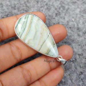 May include: A silver pendant with a green and white agate stone. The stone has a teardrop shape and is set in a silver bezel. The pendant is on a silver chain.