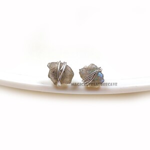 Peut inclure: Une paire de boucles d'oreilles en labradorite enveloppées de fil d'argent. Les boucles d'oreilles sont faites avec des pierres de labradorite naturelles et constituent un bijou magnifique et unique.