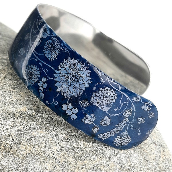 Bracelet manchette ouverte, motif fleurs blanches sur fond bleu , motif fait à partir d'un foil et  recouvert de résine, fait main et inqiue