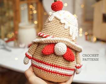 May include: Crochet pattern for a gingerbread gnome amigurumi toy. The gnome is brown with red and white accents, a white pom-pom nose, and a red bow tie. The gnome is wearing a white and red striped hat with a red cherry on top.