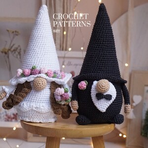 May include: Crochet patterns for a bride and groom gnome set. The bride gnome is wearing a white dress with a floral crown and brown hair. The groom gnome is wearing a black suit with a white bow tie.