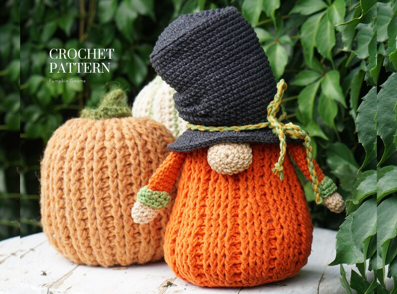 May include: Crochet pattern for a pumpkin gnome. The gnome is orange with a black hat and green accents. The gnome is sitting next to a crocheted pumpkin.