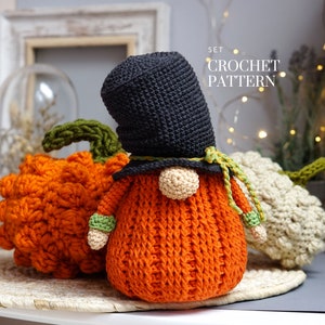 May include: A set of crochet patterns for making three fall-themed gnomes. The gnomes are dressed in orange, black, and white, and are holding pumpkins. The text "SET CROCHET PATTERN" is visible in the image.