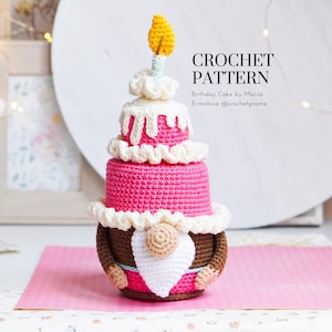 May include: A crocheted birthday cake gnome with a pink and white cake, a white frosting, and a yellow candle. The cake is three tiers high. The gnome has a brown hat, a white beard, and a pink body. The text "CROCHET PATTERN Birthday Cake by Maria Ermolova @crochetgnome" is on the image.