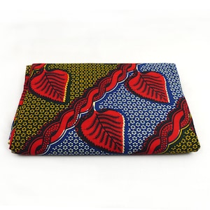 May include: A folded piece of fabric with a colorful pattern of red, blue, green, and yellow leaves. The fabric has a repeating pattern of leaves and a wavy line.