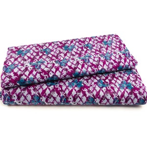 Könnte beinhalten: Ein gefaltetes Stück Stoff mit weißem Hintergrund und einem geometrischen Muster in Lila und Blau.